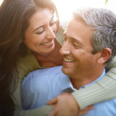 A woman hugging her husband while enjoying a walk outdoors.