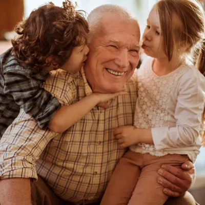 Children greeting Grandpa with a group hug.
