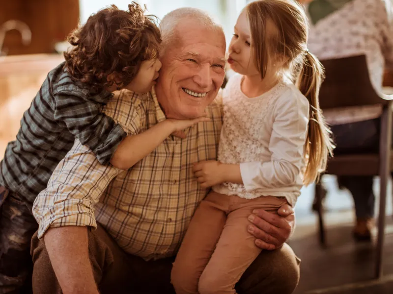 A grandfather plays with his grandchildren.